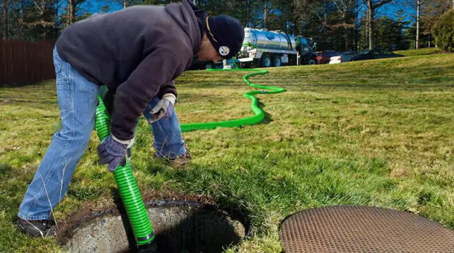 Service technician performing residential septic pumping and drainage maintenance in Fort Collins, CO